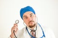 A crazy doctor with big eyes holds a stethoscope and looks into the camera