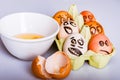 Crazy eggs terrified, Scared faces staring from egg tray at broken egg. Funny easter stories.