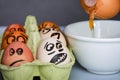 Crazy eggs terrified, Scared faces staring from egg tray at broken egg. Funny easter stories.