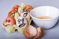 Crazy eggs terrified, Scared faces staring from egg tray at broken egg. Funny easter stories.