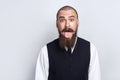 Crazy Funny face. Handsome businessman with beard and handlebar mustache looking at camera with tongue out.