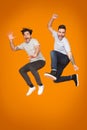 Crazy guys jumping and having fun over orange background Royalty Free Stock Photo