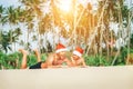 Crazy happy father and son lie on tropical sand beach in Sants h