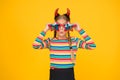 Crazy is her name. Crazy halloween child yellow background. Party girl with crazy look. Fashion kid wear red devil horns