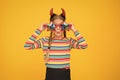 Crazy is her name. Crazy halloween child yellow background. Party girl with crazy look. Fashion kid wear red devil horns