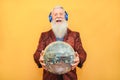 Crazy hipster man listening music with headphones while holding disco ball - Party concept Royalty Free Stock Photo