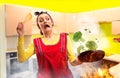 Crazy housewife in apron cooking broccoli on fire Royalty Free Stock Photo