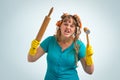 Crazy housewife with kitchen roller and meat hammer Royalty Free Stock Photo