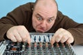 A crazy and inadequate man controls the equalizer on a mixing console in a state of narcotic excitement in a music studio Royalty Free Stock Photo