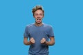 Crazy irritated teen boy is shouting on blue background. Royalty Free Stock Photo