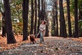 Crazy jogging with a dog in the autumn park. Woman running in the park with a dog on a leash with joyful emotions and pleasure Royalty Free Stock Photo