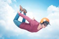 Crazy man in red helmet and goggles is flying in the sky. Concept of extreme jumping