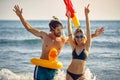 Crazy man with rubber duck and smiling girl with water gun having fun on beach Royalty Free Stock Photo