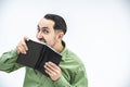 Crazy man tears out a sheet of paper from black notebook with a help of his teeth. Royalty Free Stock Photo