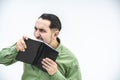 Crazy man tears out a sheet of paper from black notebook with a help of his teeth. Royalty Free Stock Photo