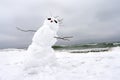 Crazy, melting snowman on a winter beach. Royalty Free Stock Photo