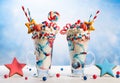 Crazy milk shake with ice cream,whipped cream, marshmallow,cookies and colored candy in glass. Sweet dessert for Fourth of July.