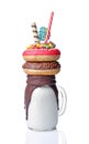 Crazy milk shake with pink and chocolate donuts, color candy and straw in glass jar