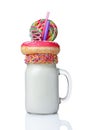 Crazy milk shake with pink donut, color candy and lollipop in glass jar