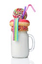 Crazy milk shake with pink donut, color candy and lollipop in glass jar