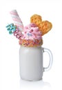 Crazy milk shake with pink whipped cream, marshmallow, waffle and colored candy in glass jar