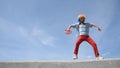 Crazy mime dance on the parapet with a tambourine against the sky. Funny clown antics