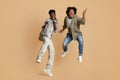 Crazy Mood. Two Overjoyed Black Guys Jumping Over Beige Studio Background Royalty Free Stock Photo