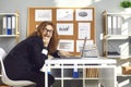 Crazy office worker sitting at laptop, scheming funny prank on coworkers and giggling