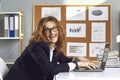 Crazy office worker sitting at desk with laptop, smiling and doing financial reports Royalty Free Stock Photo