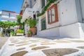 Crazy paving leading past large terr cotta urn to green chairs