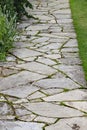 A crazy paving walkway between a flower bed and a lawn in an English country garden Royalty Free Stock Photo