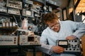 Crazy scientist holds electrical device in lab