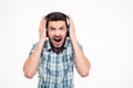 Crazy screaming bearded man listening to music using headphones