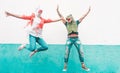 Crazy senior couple jumping wearing t-rex and chicken mask - Old trendy people having fun together- Absurd and funny trend concept