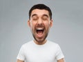 Crazy shouting man in t-shirt over gray background Royalty Free Stock Photo