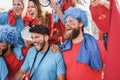Crazy sport fans playing drums and screaming while supporting their team - Focus on center man Royalty Free Stock Photo