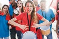 Crazy sport fans playing drums and screaming while supporting their team - Focus on center woman face Royalty Free Stock Photo