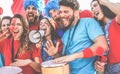 Crazy sport fans playing drums and screaming while supporting their team - Football supporters having fun inside stadium for Royalty Free Stock Photo