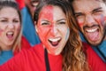 Crazy sport fans screaming while supporting their team - Focus on center girl face Royalty Free Stock Photo