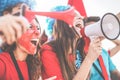 Crazy sport fans screaming while supporting their team - Football supporters having fun inside stadium for soccer match - Event Royalty Free Stock Photo