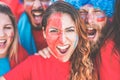 Crazy sport fans screaming while supporting their team - Football supporters with paited faces having fun inside stadium for Royalty Free Stock Photo