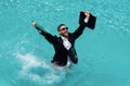 Crazy summer business. Fun business lifestyle. Handsome excited business man in suit jump with laptop in swimming pool Royalty Free Stock Photo