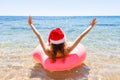 Crazy swimming with inflatable donut and christmas hat on the beach in summer sunny day Royalty Free Stock Photo