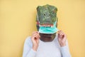 Crazy woman wearing t-rex and medical protection masks - Quarantine isolation lifestyle during coronavirus time - Absurd and funny