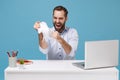 Crazy young bearded man in light shirt work at white desk with pc laptop isolated on pastel blue background. Achievement Royalty Free Stock Photo