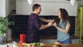 Crazy young couple in love dancing together rocknroll dance in the kitchen at home on holidays