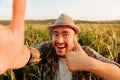 Crazy young farmer stands in the field and makes faces, looking at camera, Royalty Free Stock Photo