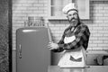 Crazy young male chef cook or baker man in white apron chefs hat posing in kitchen background. Royalty Free Stock Photo