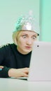 Crazy young woman with aluminum hat reacting badly on the conspiracy theory post about 5g microwaves and covid-19