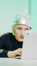 Crazy young woman with aluminum hat reacting badly on the conspiracy theory post about 5g microwaves and covid-19